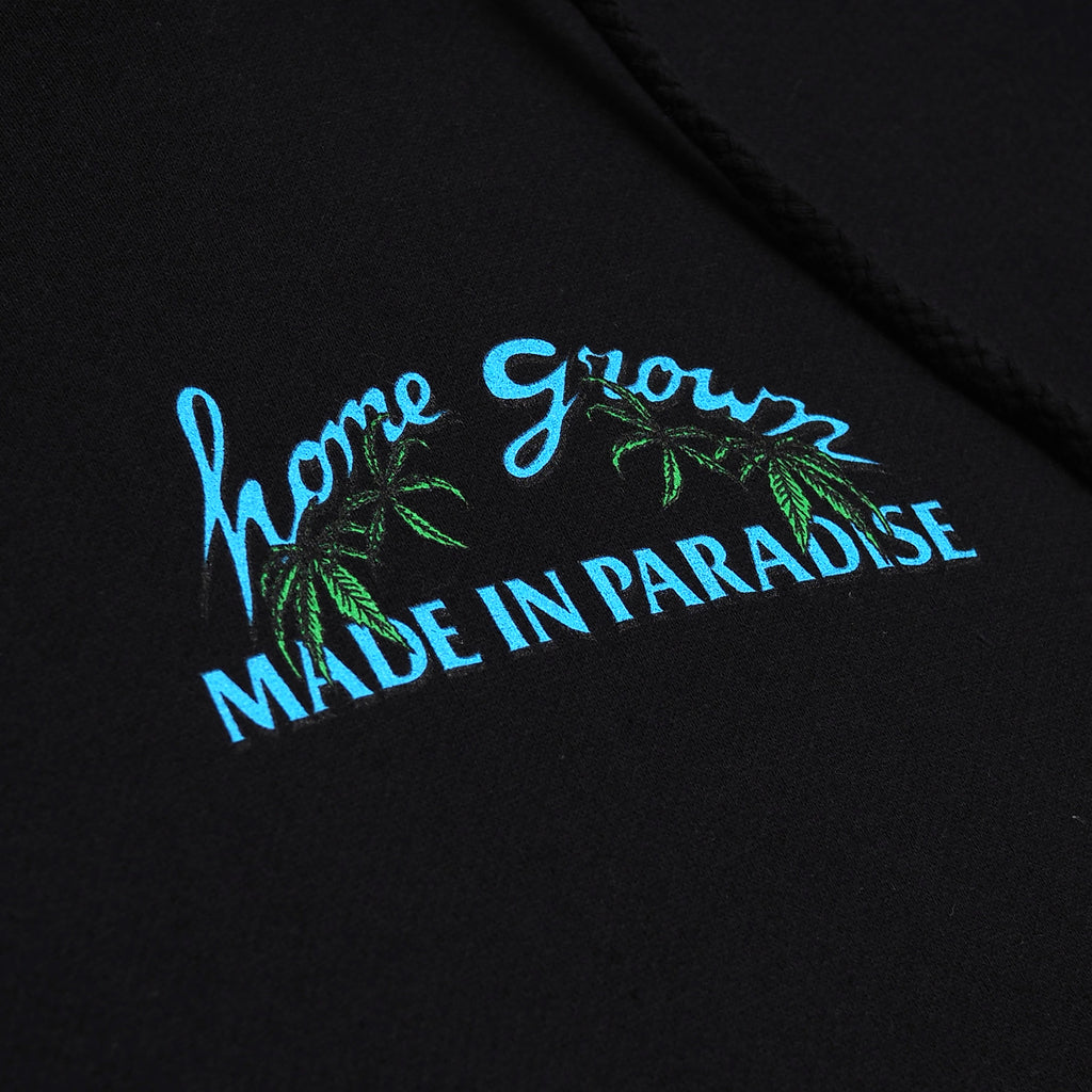Close-up view of front graphic print of Made in Paradise Homegrown Collection "HOME GROWN" black hoodie