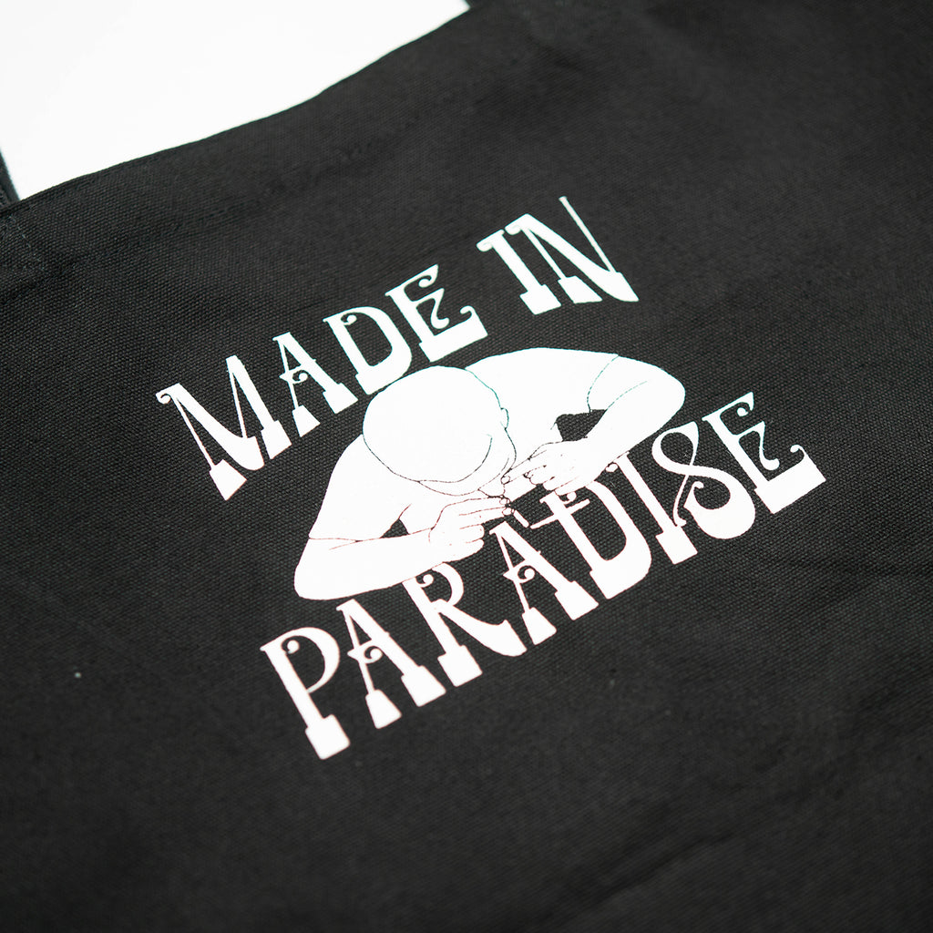 Close-up view of back graphic print of Made in Paradise World Drug Trade Collection "COCAINE PRICES" black tote bag